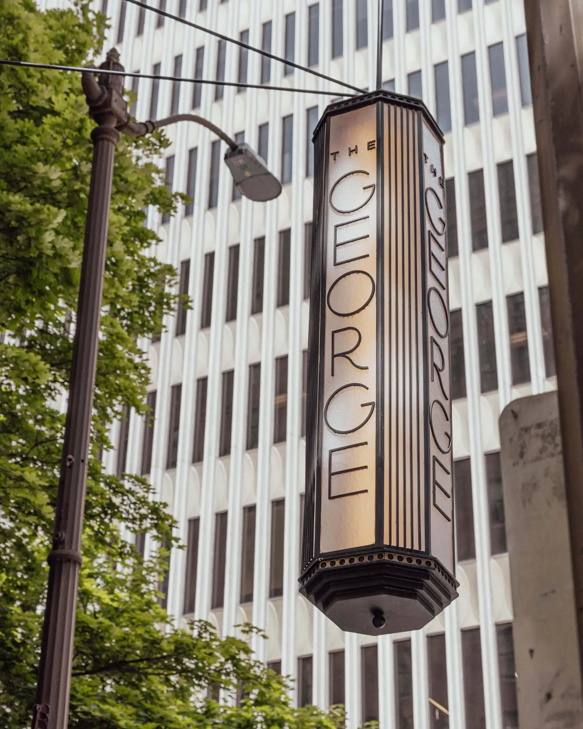 Hanging illuminated signage outside The George.